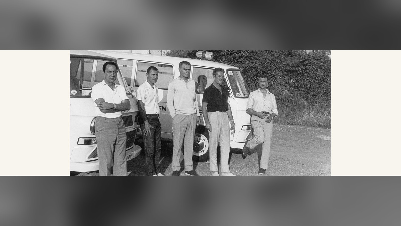 Fotografía en blanco y negro de los primeros voluntarios de DYA junto a sus furgonetas en 1966